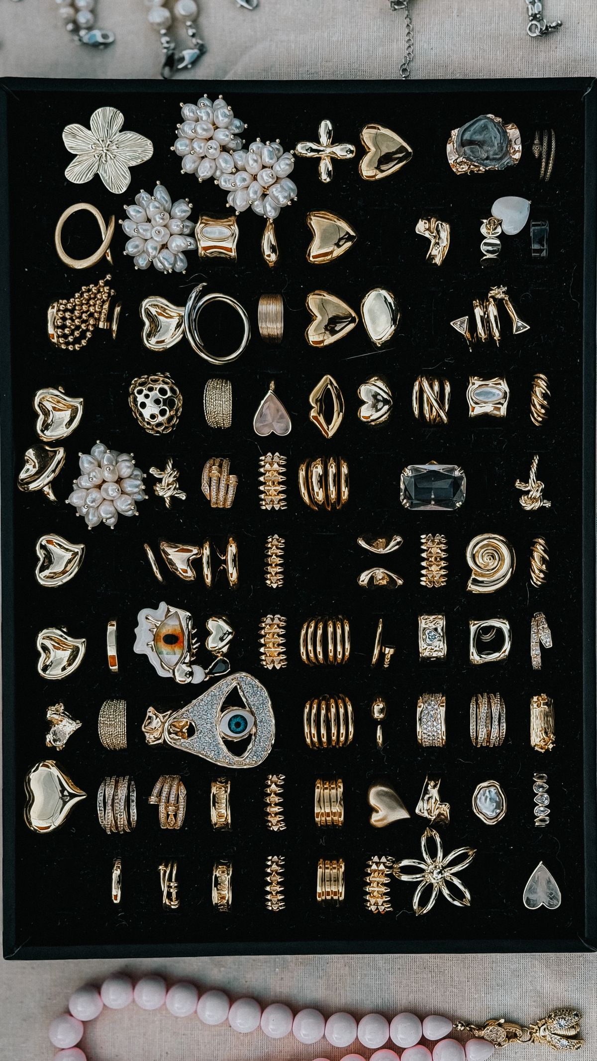 render of gold and diamond earrings arranged in a black display box
