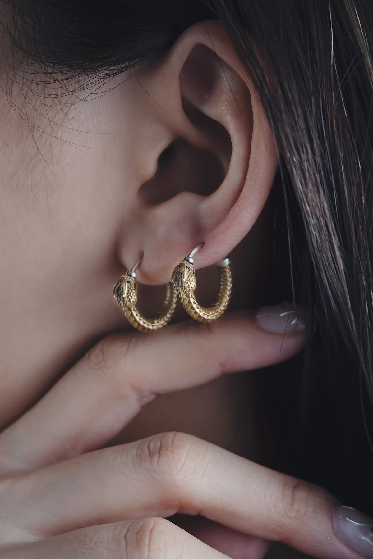 gold hoop earrings shown worn on an ear