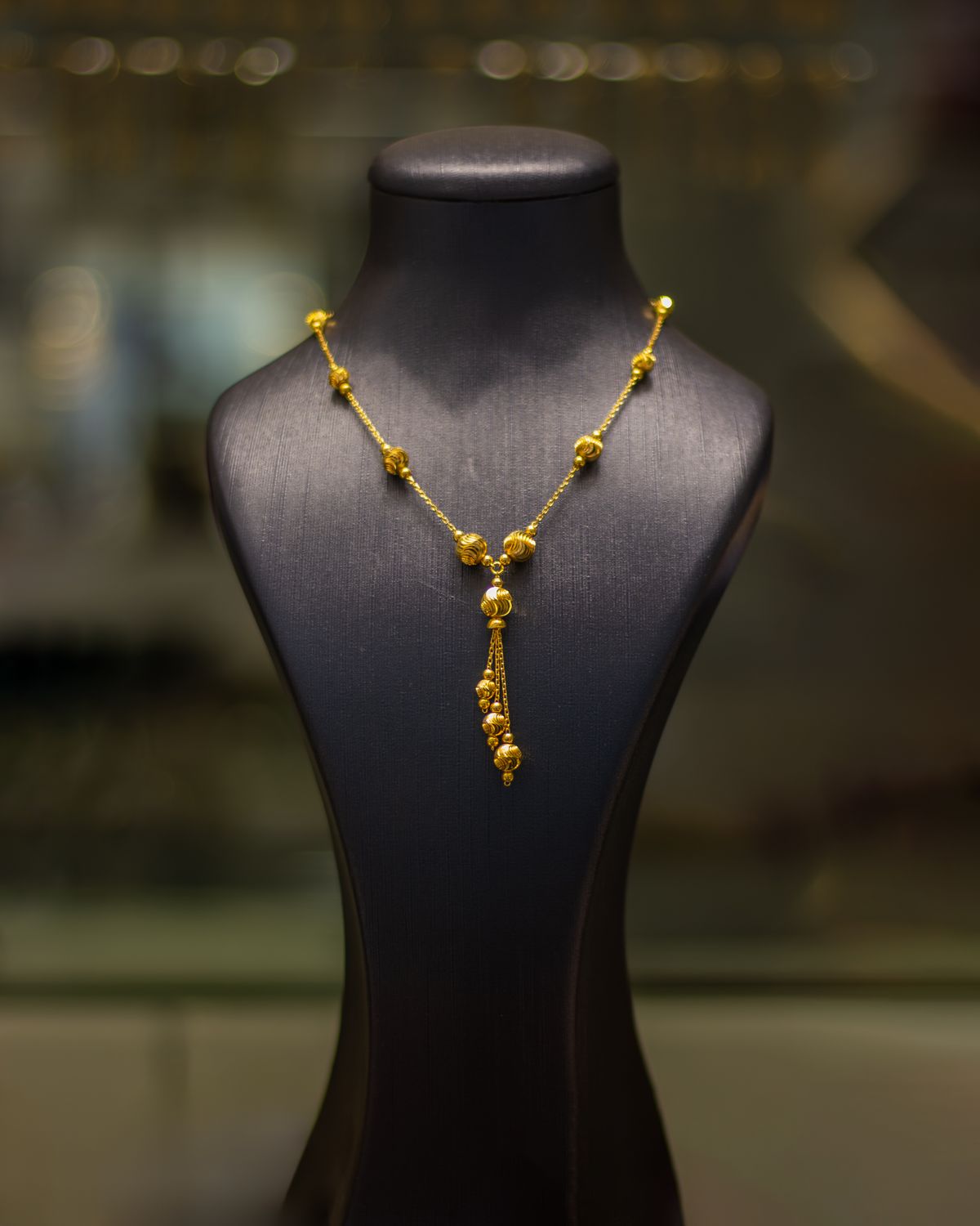 gold pendant necklace shown on a display bust