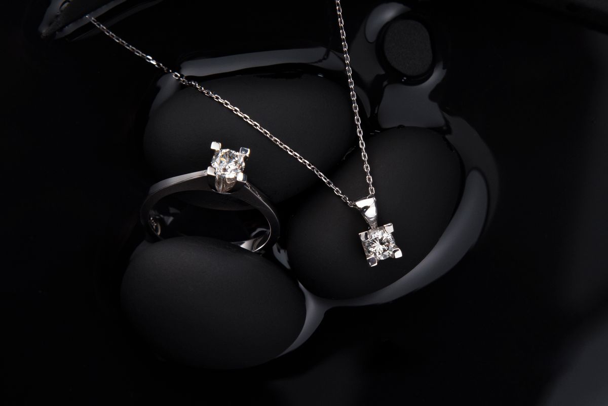cinematic jewelry product animation still of a diamond pendant with light sweep